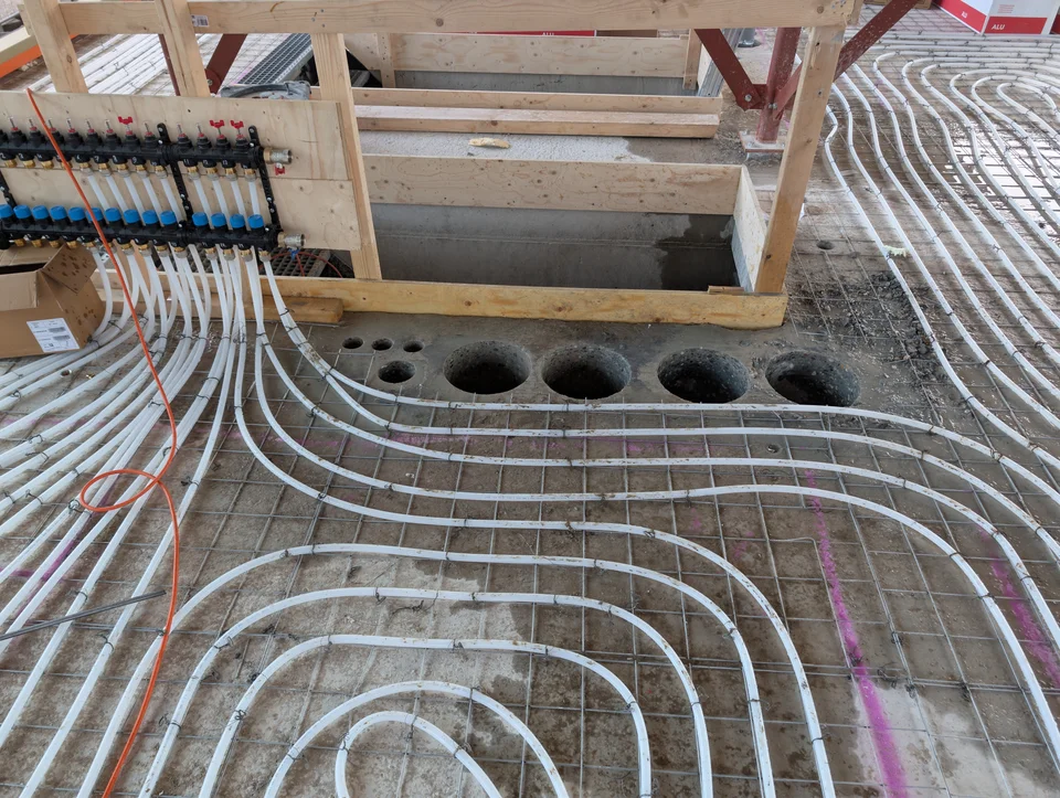 Rij ronde boringen naast een trapopening in de betonvloer
